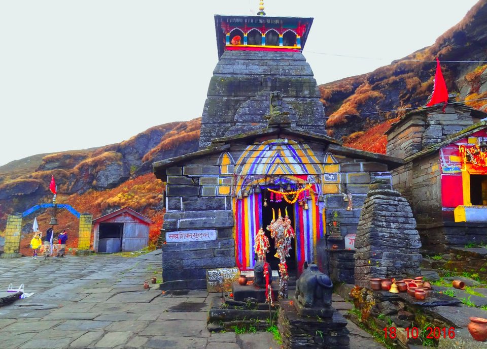 Tungnath temple in the Garhwal Himalayas, prayer flags and stone shrines under a bare hillside
